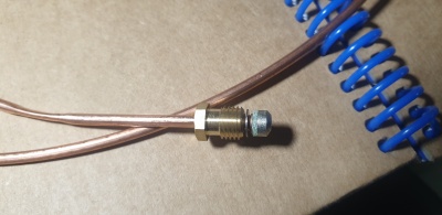 Conector metálico com porca em fios de cobre perto de mola azul