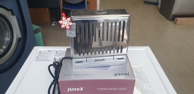 Torradeira metálica prateada JuneX sobre caixa roxa e branca numa loja