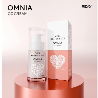 Frasco de creme CC OMNIA New Silhouette com embalagem rosa e branco, exibido em superfície rosa metálica