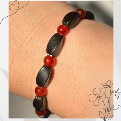 Pulseira preta e vermelha para emagrecimento no pulso