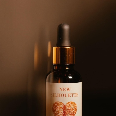 Frasco castanho com conta-gotas e etiqueta com texto e coração decorativo