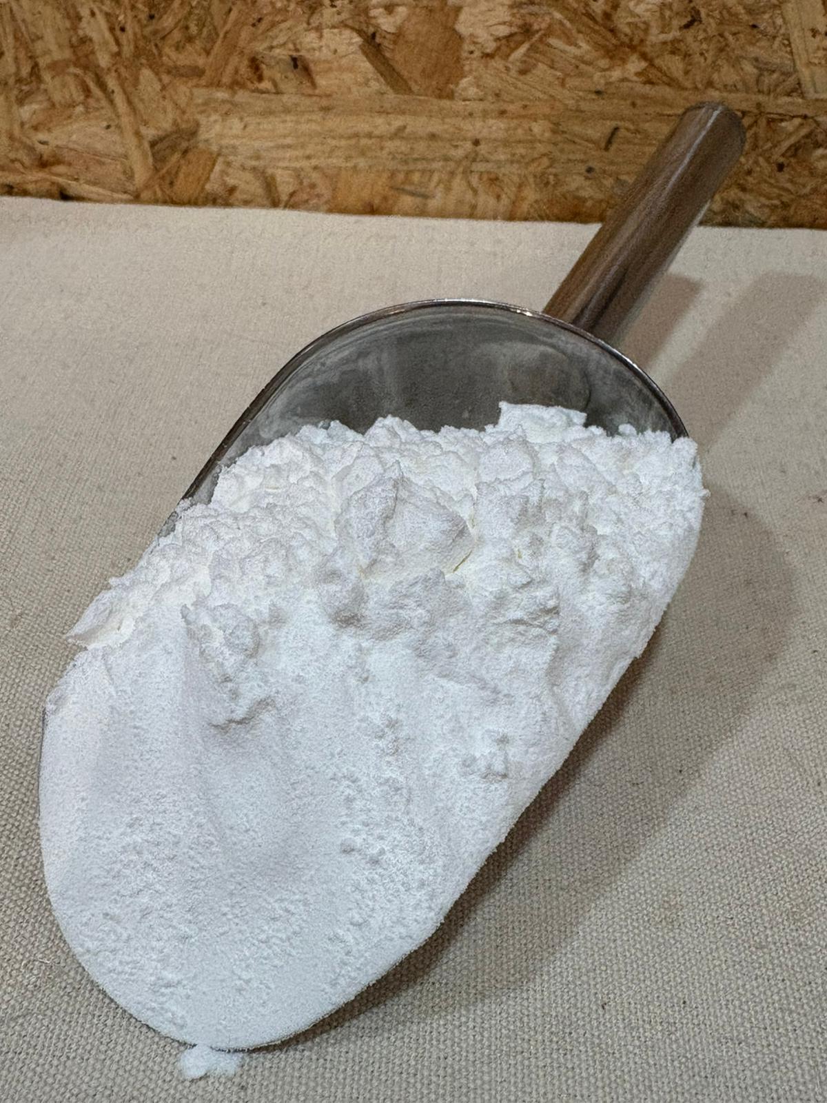 Farinha de Araruta BIO Pá metálica com pó branco sobre tecido bege e fundo de madeira OSB