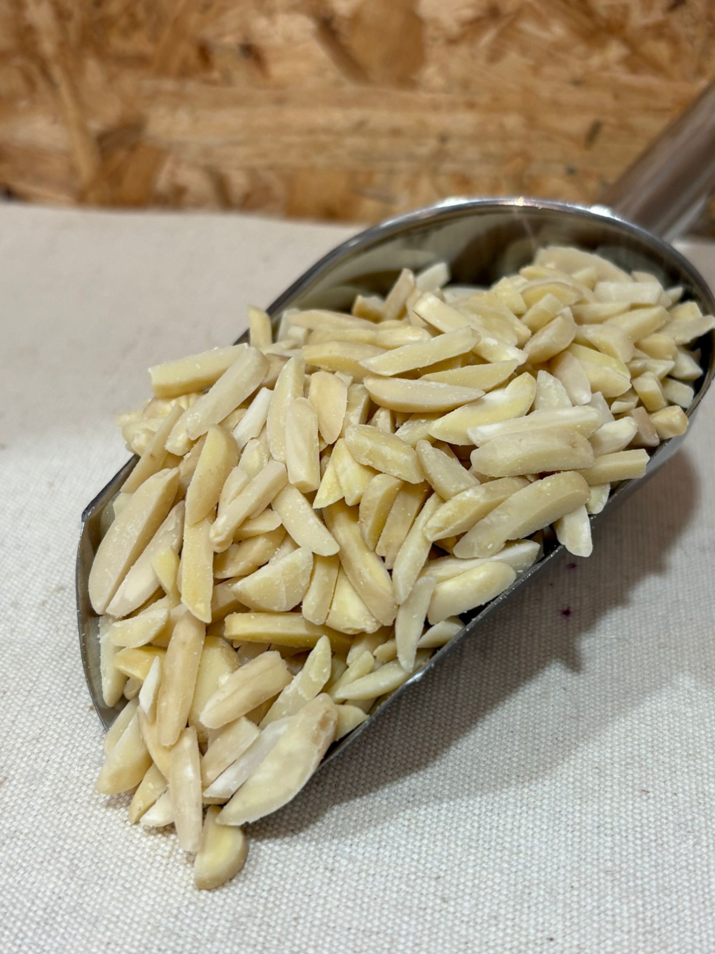 Amêndoa Palitada Amêndoas laminadas em espiga metálica sobre tecido claro