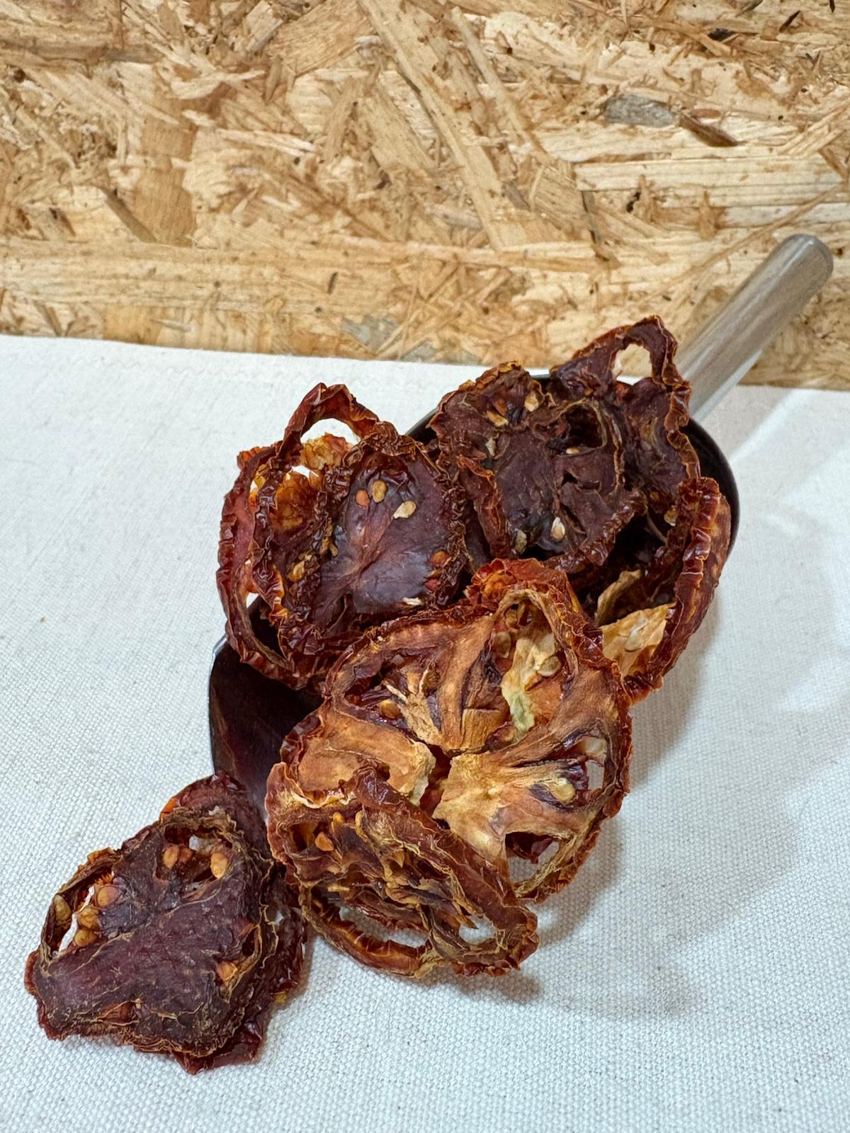 Tomate Desidratado fatias secas de tomate castanho-avermelhado numa colher metálica