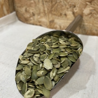 Colher metálica com sementes de abóbora verdes descascadas