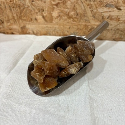 Colher metálica com cristais de açúcar castanho sobre pano branco