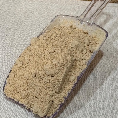 Pá de plástico transparente com pó bege claro sobre tecido claro