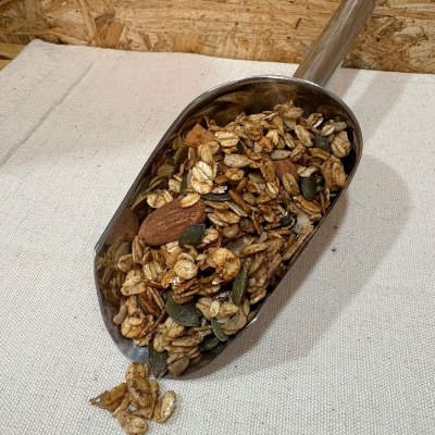 Pá metálica com granola variada sobre tecido bege