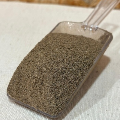 Pá plástica transparente com pó castanho claro em superfície clara