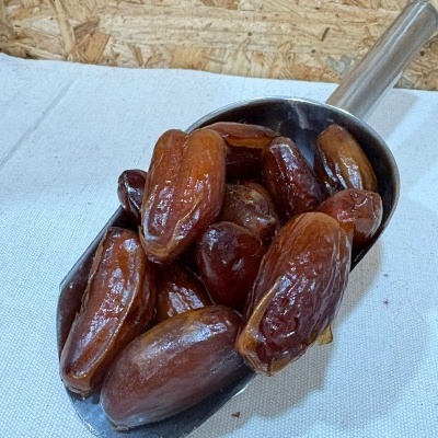 Tâmaras castanhas numa pá metálica sobre tecido branco