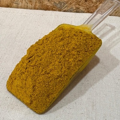 Pá transparente com pó amarelo-alaranjado sobre tecido claro