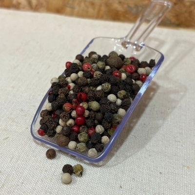 Colher com mistura de pimentas coloridas sobre tecido claro