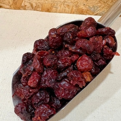 Colher metálica com bagas vermelhas secas em tecido bege