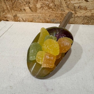 Colher metálica com doce colorido de gelatina polvilhado com açúcar