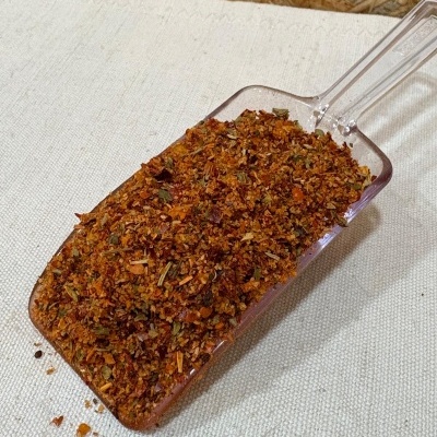 Mistura de especiarias secas vermelhas com verde numa cúvet transparente sobre tecido bege