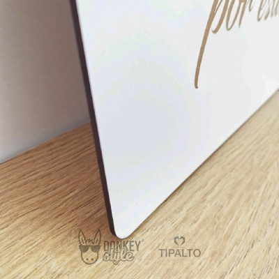 Placa branca com texto dourado parcialmente visível e logótipos Donkey Style e TIPALTO sobre superfície de madeira clara