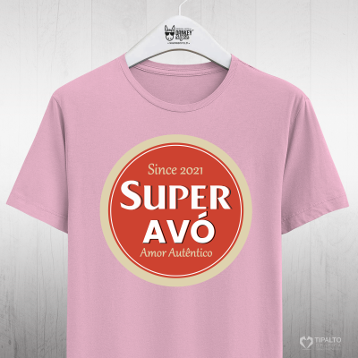 Camiseta rosa com estampa 'SUPER AVÓ' vermelha e bege numa parede de madeira clara