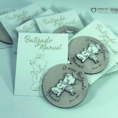 Etiqueta de madeira redonda com anjo e texto, cartão branco com texto Batizado Manuel e anjo desenhado