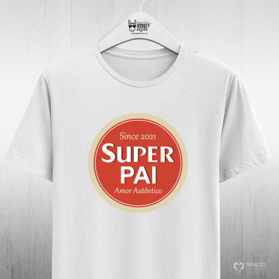 T-shirt branca com estampa circular e texto 'SUPER PAI' pendurada num cabide branco.