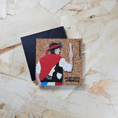 Quadrado de cortiça com ilustração e texto próximo a envelope preto numa superfície de madeira