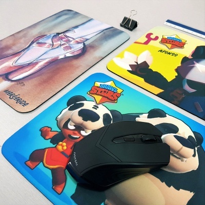 Três tapetes de rato coloridos com personagens e texto BRAWL STARS, e um rato preto em cima do tapete azul