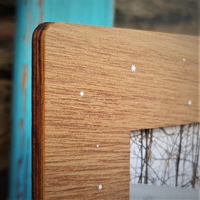 Moldura de madeira com decoração de estrelas brancas e fotografia de árvores