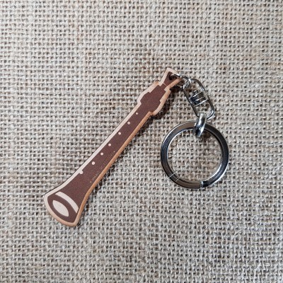 Porta-chaves de instrumento musical em madeira com anilha metálica sobre tecido de juta