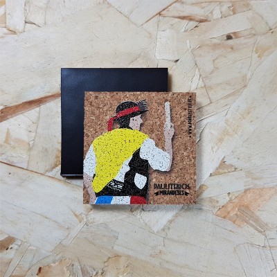 Magneto decorativo quadrado em cortiça com figura colorida ao lado de caixa preta