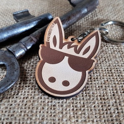 Chaveiro em madeira de cabeça de burro com óculos e chave antiga em tecido rústico