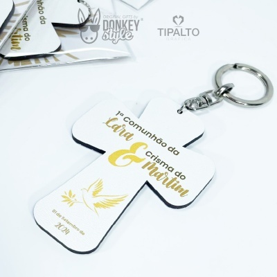 porta-chaves em forma de cruz branca com texto dourado e ilustração de pomba