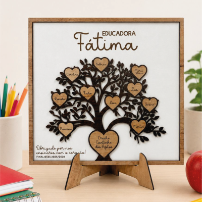 Placa decorativa de madeira com árvore e corações gravados com nomes e texto educativo em mesa de estudo