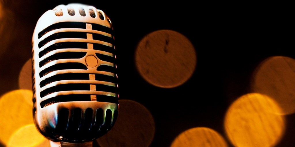 Microfone retro metálico com fundo desfocado de luzes circulares amarelas e marrons