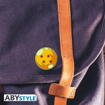 Mochila azul escuro com alça de pele castanha e pin decorativo laranja com estrelas vermelhas