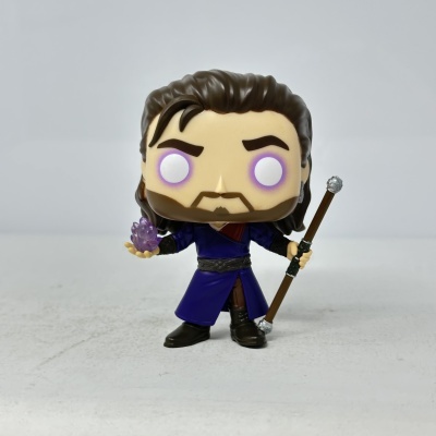 Figura de vinil colecionável com cabelo castanho e roupa azul segurando flor roxa e bengala