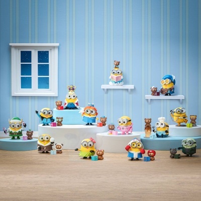 Figuras de personagens Minions em vários disfarces com ursos pequenos numa exibição azul com janela branca