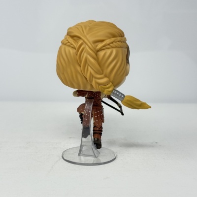 Figura estilizada com cabelo loiro e traje marrom sobre base transparente