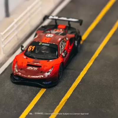 Carro de corrida vermelho e preto com número 51 em pista de corrida