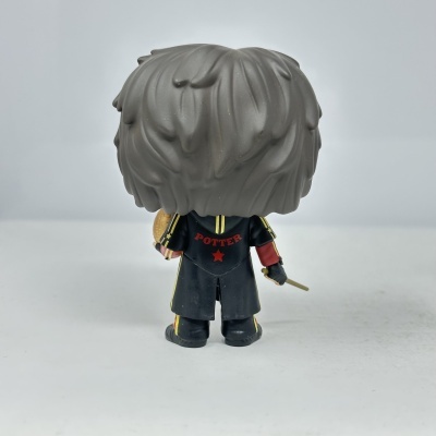 Figura colecionável de costas com cabelo castanho e casaco preto com palavra POTTER em vermelho