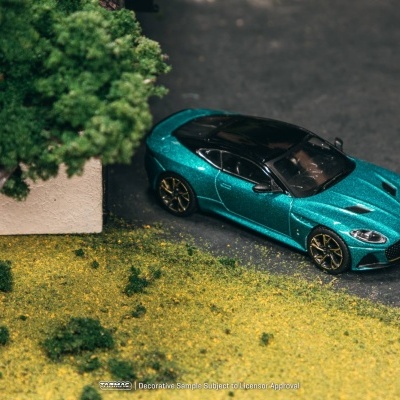 Modelo de carro desportivo azul metálico estacionado junto a árvore e relva