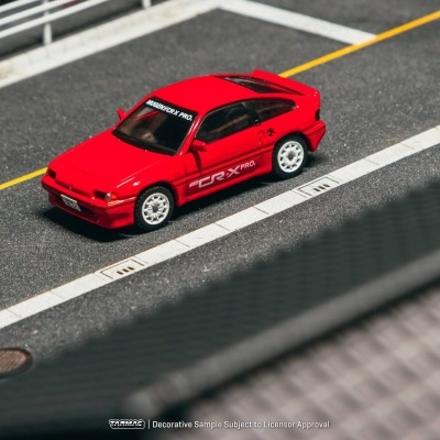 Miniatura de carro desportivo vermelho com texto CR-X PRO. em estrada com guardas brancas.
