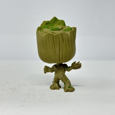 Figura de vinil tipo Funko Pop do personagem Groot com corpo e cabeça de madeira verde.