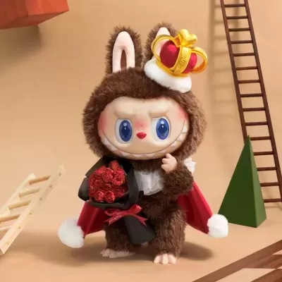 Figura de peluche castanho com capa vermelha e coroa segurando flores vermelhas