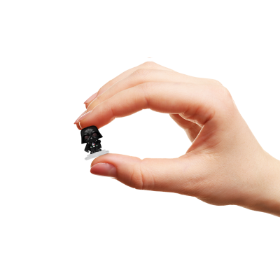 Mão segurando pequena figura preta de Darth Vader