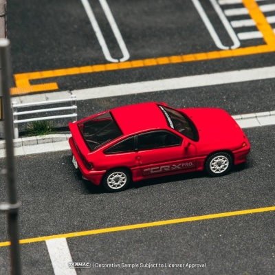 Miniatura de carro desportivo vermelho com texto CR-X PRO. num cenário de estrada