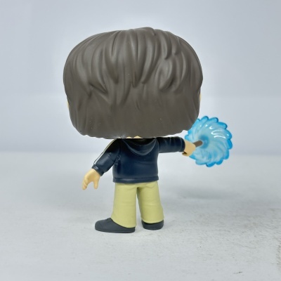 Figura Funko Pop vista de costas com cabelo castanho e varinha azul