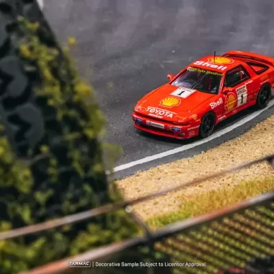 Miniatura de carro vermelho de corrida com logótipos Shell e Toyota numa pista curva