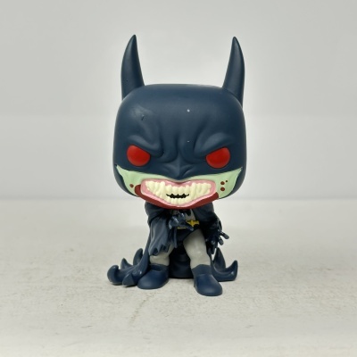 Boneco de vinil do Batman com olhos vermelhos e boca aberta mostrando dentes