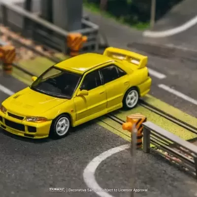 Miniatura de carro amarelo num cenário de estrada em miniatura