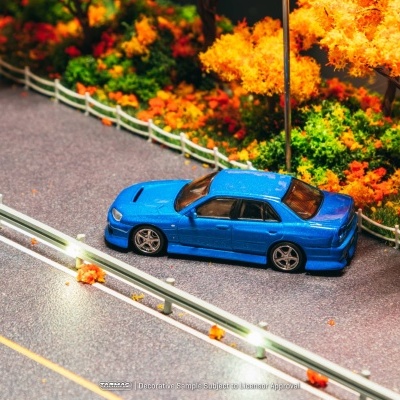 Carro de brinquedo azul numa estrada com guarda-corpos e árvores outonais