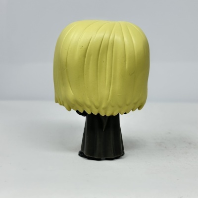 Boneco em vinil com cabelo amarelo e roupa preta visto de trás